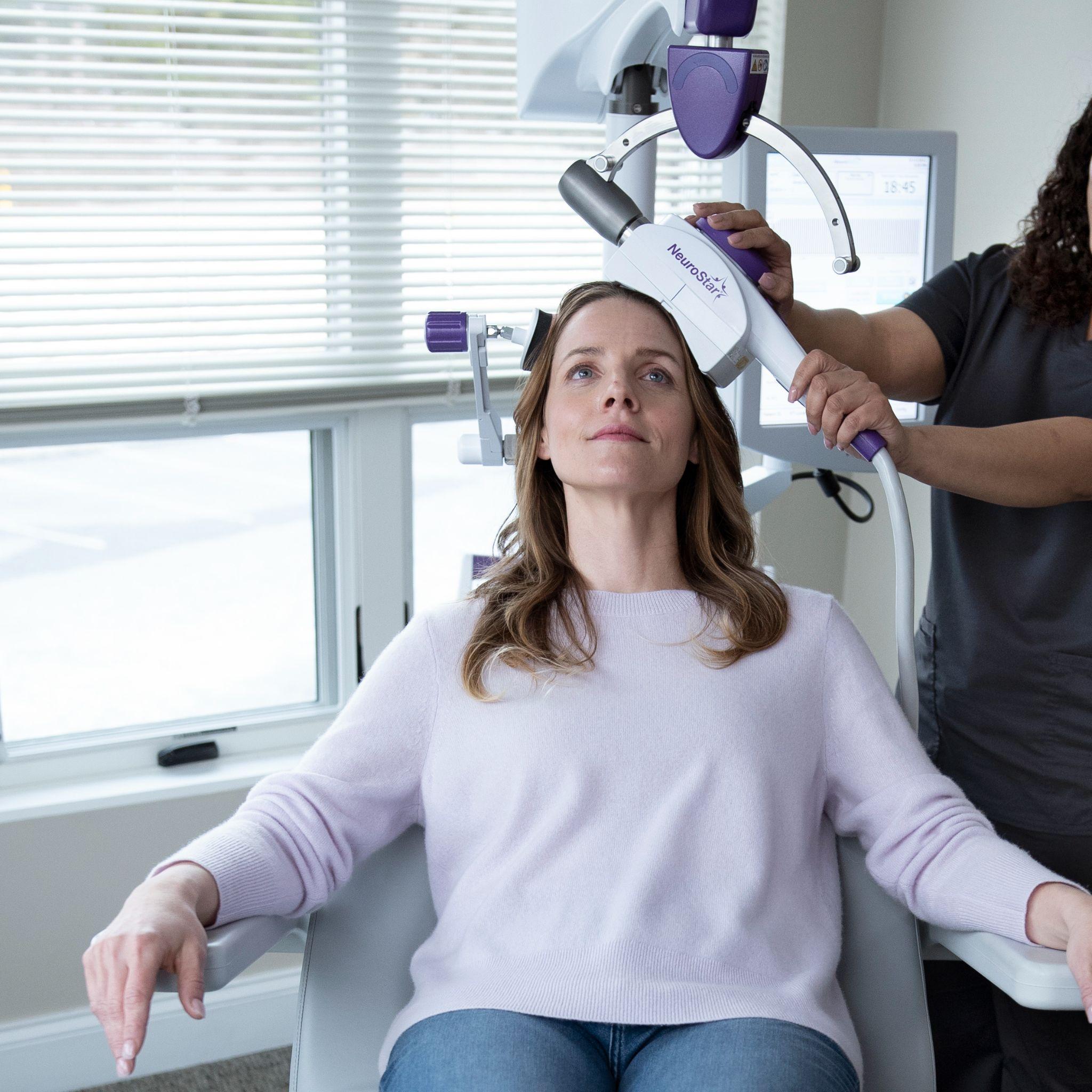Patient seated comfortably while receiving a NeuroStar TMS therapy treatment.